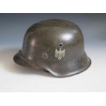 A WWII German Army SD Helmet, rim stamped 1753, with leather chin strap
