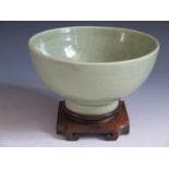 A Chinese Celadon Bowl decorated with figures and Chinese character marks with a key pattern rim and