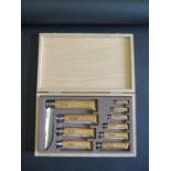 An OPINEL 10-PIECE CARBON STEEL FOLDING KNIFE SET IN A WOODEN CASE