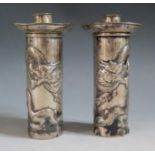 A Pair of Chinese Silver Cylindrical Candlesticks each embossed with two dragons and with detachable