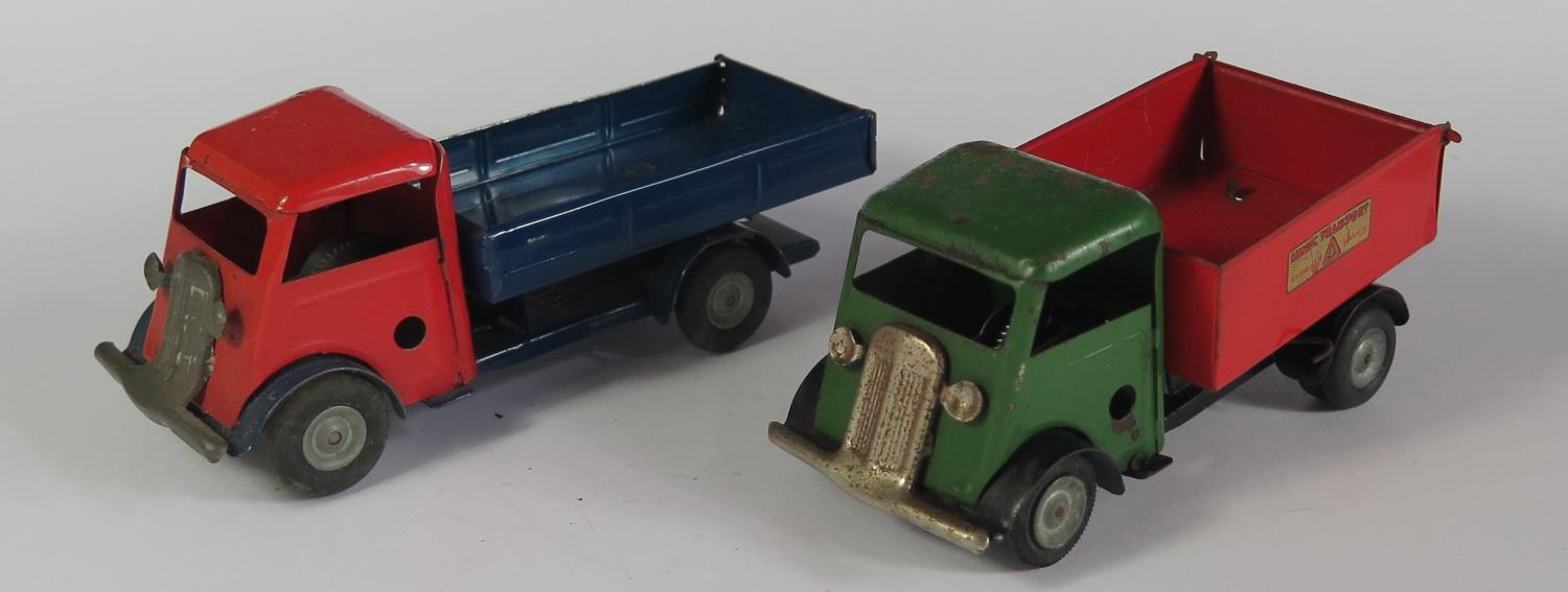 Two Triang Minic Clockwork Trucks. One in red and blue with working motor the other has a tipping