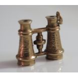 A 9ct Gold Charm in the form of a pair of binoculars, 0.9g, 12mm long