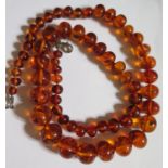 A Graduated Orange Amber Bead Necklace with inclusions, 52cm, 30g
