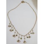A Peridot and Blister Pearl Necklace in an unmarked gold setting, 9.4g, 43cm long, longest drop 32mm