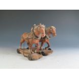 A Pair of 19th Century Composite Cart Horses on wheeled wooden plinths (Overall length 19.5cm