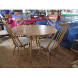 An Ercol Light Elm Drop Leaf Table with four spindle back chairs