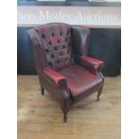 A Modern Wing Back Fireside Chair in oxblood leather upholstery