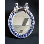 A 19th Century Porcelain Framed Mirror decorated with floral border and putti to the top, 34cm high