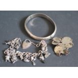 A Silver Charm Bracelet, silver hinged bangle (64.7g) and coin bracelet