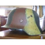 A German M35 Helmet with camouflage paint and SS motif, stamped mark unclear