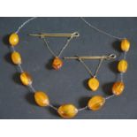 A Pair of Russian Kaliningrad Amber Factory Clip Brooches and a necklace, 39.3g
