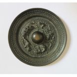 A Chinese Bronze Mirror decorated with dragon and other figures, 9.6cm diam.