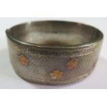 A George VI Silver Hinged Bangle with gold flowers, engine turned and Greek key decoration,