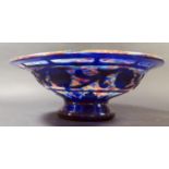 A Multi-Coloured Glass Footed Bowl with the outer body cut with a scrolling foliate border, 29.5cm