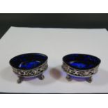 A Pair of Victorian Pierced Silver Oval Salts decorated with foliate work and with blue glass