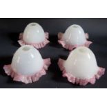 A Set of Four Opaque Glass Lamp Shades with pink accented frilly edges, 20cm diam. 11cm high, 3cm