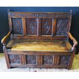 An Antique Carved Oak Settle, the back panel carved with the date 1634, later restoration, 132cm