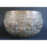 A Large Burmese Silver Thabeik Bowl decorated figures in various poses with foliate scroll