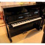 Yamaha (c1977) A Model U1H upright piano in a bright ebonised case.