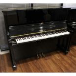 Kawai (c1985) An upright piano in a traditional bright ebonised case;
