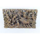 An Indonesian carved and pierced wooden storyboard panel, depicting figures and animals,
