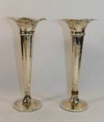 A pair of Edwardian silver trumpet shaped vases, Birmingham 1909, with wavy rims and loaded bases,