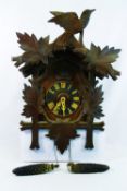 A 20th century Black Forest cuckoo clock, of typical bird and leaf form,