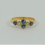 An early 20th century yellow metal sapphire and a diamond 6-stone ring,