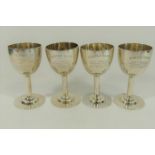 Four small silver coloured metal presentation goblets, each marked 'STERLING',