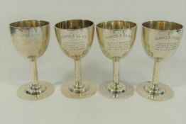 Four small silver coloured metal presentation goblets, each marked 'STERLING',