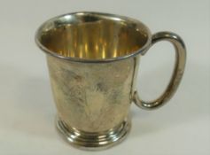 A small christening cup, with C scroll handle raised on circular foot, Birmingham 1954,