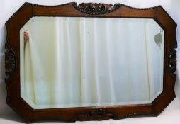 An early 20th century oak framed wall mirror with octagonal bevel glass plate,