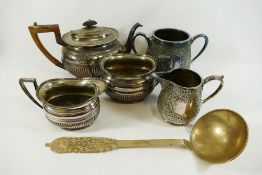 A large brass ladle with hammered design, 33cm long, a silver plated three piece teaset,