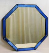 An octagonal glass mirror in the Venetian style, with blue glass surround,