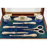 An Edwardian silver mounted manicure set, Birmingham 1911, comprised of two small glass jars,