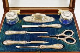 An Edwardian silver mounted manicure set, Birmingham 1911, comprised of two small glass jars,