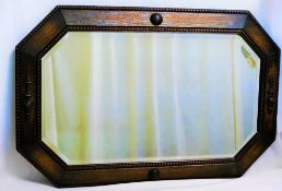 An early 20th century oak framed wall mirror with octagonal bevel glass plate,