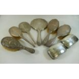 A silver backed three piece dressing table set comprised of a pair of brushes and a hand mirror,