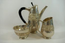 A three-piece silver coloured metal coffee set,