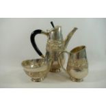 A three-piece silver coloured metal coffee set,