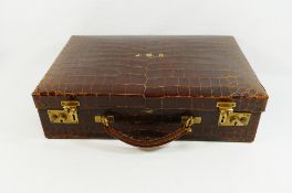 A crocodile leather documents case with brass fittings, retailed by John Pound and Co.