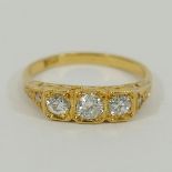A yellow metal diamond 3-stone ring with pierced and carved gallery,