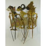 Five Indonesian Wayang Kulit painted leather shadow puppets, with horn supports,