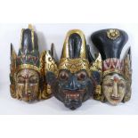 Three Indonesian carved and painted wooden masks, converted to wall decorations,