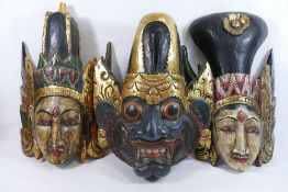 Three Indonesian carved and painted wooden masks, converted to wall decorations,