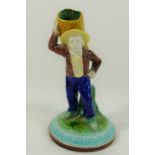 A Royal Worcester porcelain figural spill vase of a farm hand carrying a sack on his back with