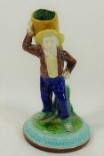 A Royal Worcester porcelain figural spill vase of a farm hand carrying a sack on his back with