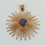 A yellow metal star burst pendant set with a single synthetic colour change sapphire, stamped '18K',