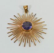 A yellow metal star burst pendant set with a single synthetic colour change sapphire, stamped '18K',