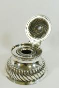 A late Victorian silver circular ink well, with half reeded body and hinged lid,